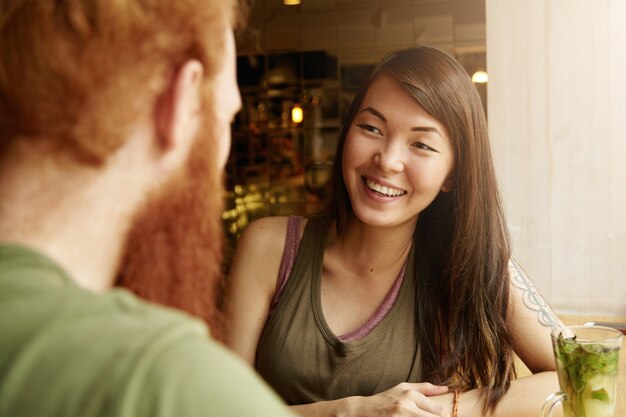 Brunette woman and ginger man sitting in cafe