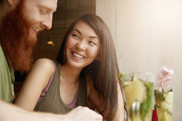 Brunette woman and ginger man sitting in cafe