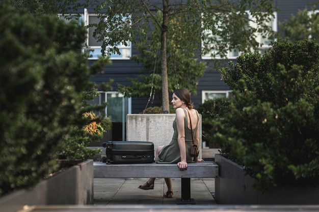 Free photo brunette woman sitting on cement seat on urban park