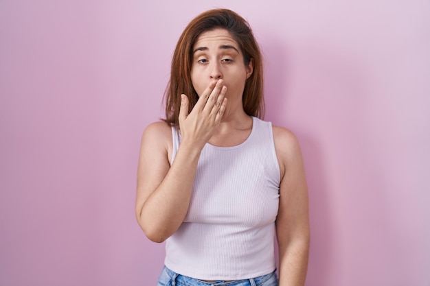 Free Photo brunette woman standing over pink background bored yawning tired covering mouth with hand restless and sleepiness