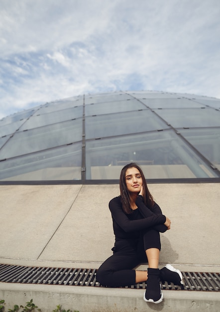 Free photo brunetter girl next to a modern building