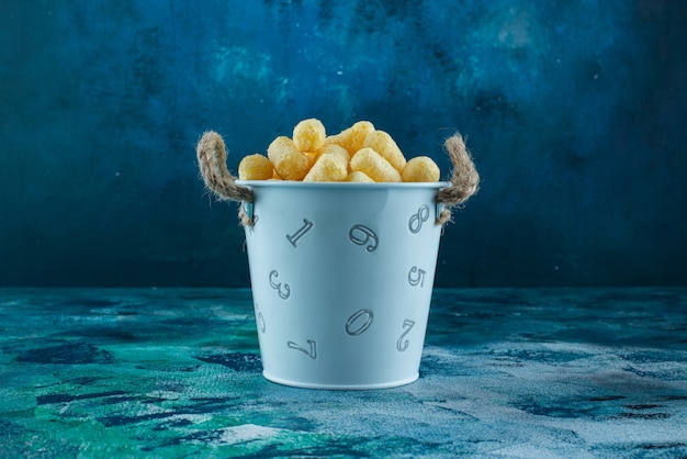 A bucket of corn sticks , on the marble table.