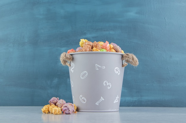 Free photo a bucket full of sweet multicolored popcorn .