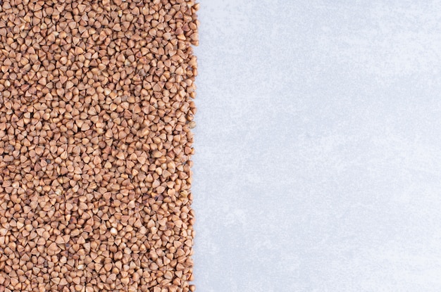 Buckwheat arranged into a rectangular pile on marble surface