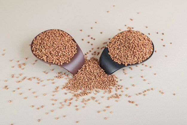 Buckwheat seeds in a dish on concrete.