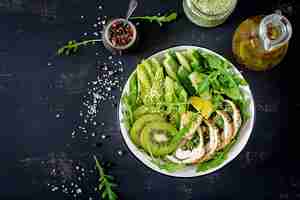 Free photo buddha bowl dish with chicken fillet, avocado, cucumber, fresh arugula salad and sesame