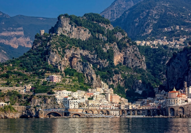 building between mountain and seashore during daytime