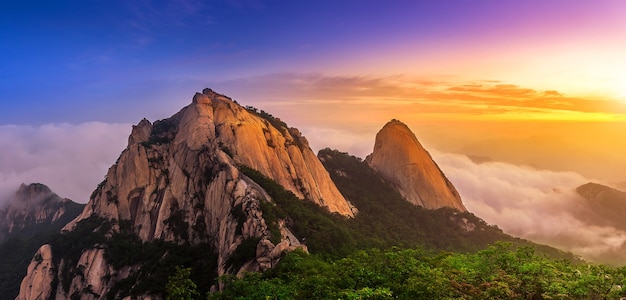 Bukhansan mountains is covered by morning fog and sunrise in Seoul,Korea.(Dark tone)