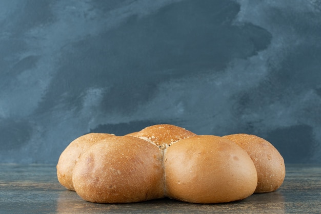 Free photo bun of fresh white bread on marble background