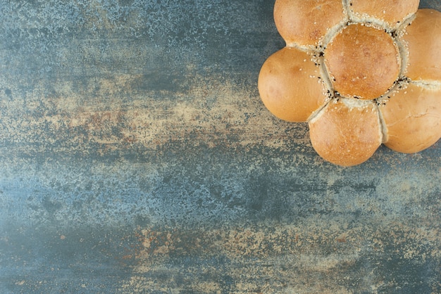 Free photo bun of fresh white bread on marble background