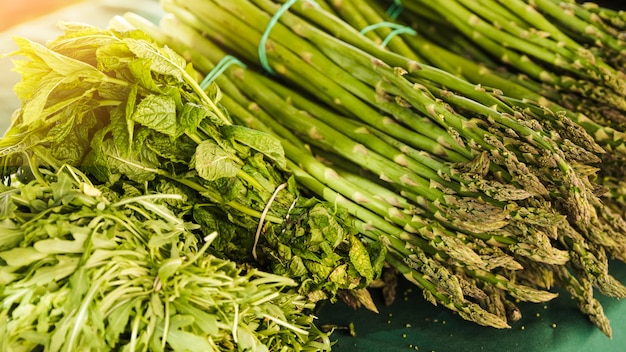 Bunch of asparagus with arugula and mint at market