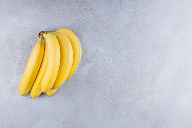 Bunch of banana placed on a stone table .