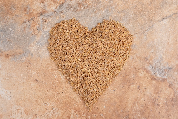 Bunch of barley formed like heart on orange background