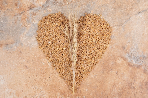 Free photo bunch of barley formed like heart on orange background