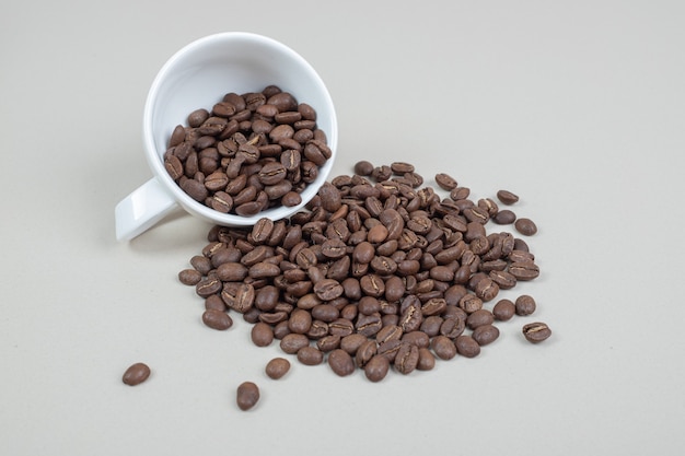 Bunch of coffee beans out of white mug