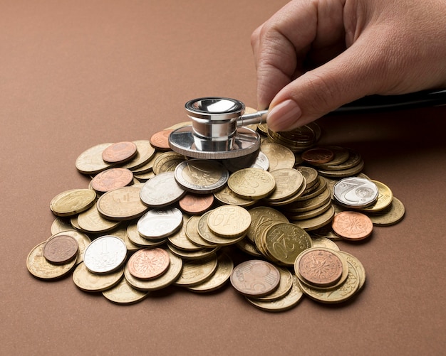 Free Photo bunch of coins with person using a stethoscope