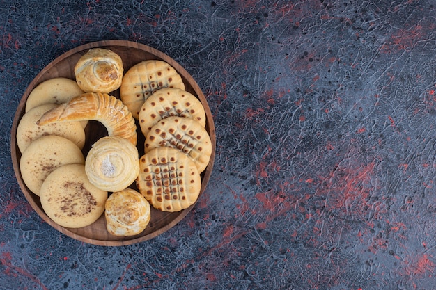 Bunch of cookies on a small tray on abstract table.