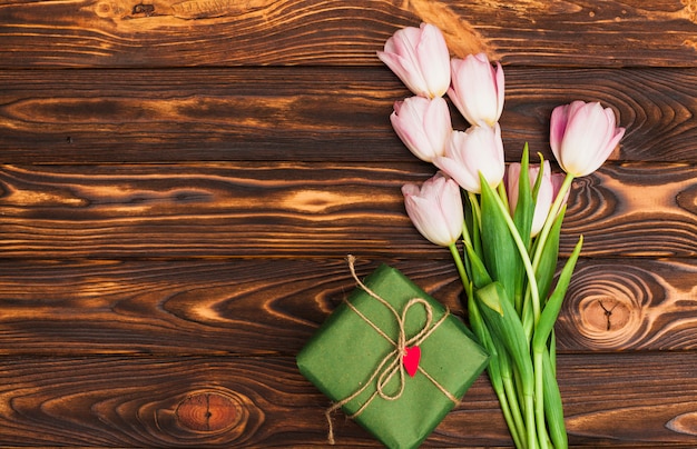 Bunch of flowers and gift box on table 