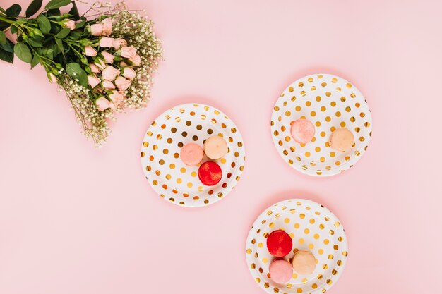 Bunch of flowers near plates with dessert