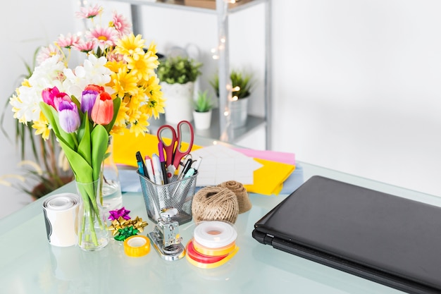 Free Photo bunch of fresh flowers with stationeries on desk