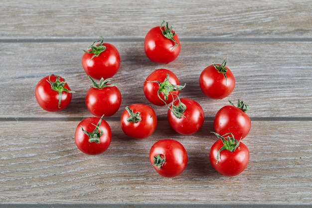 Bunch of fresh juicy tomatoes on wooden table.