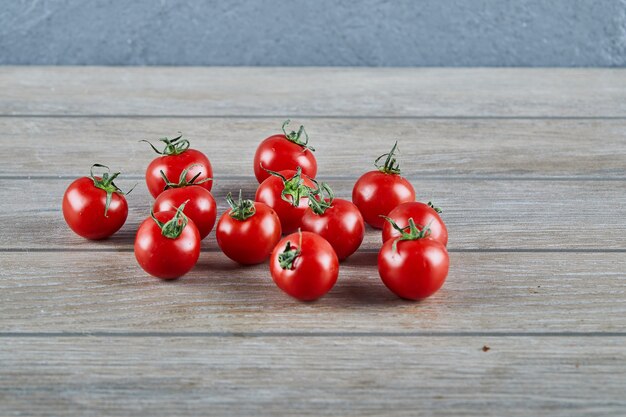 Bunch of fresh juicy tomatoes on wooden table.