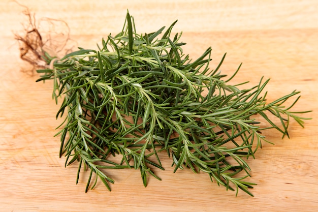 Free photo bunch of fresh rosemary on wooden board