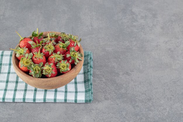 Bunch of fresh strawberries in wooden bowl. High quality photo