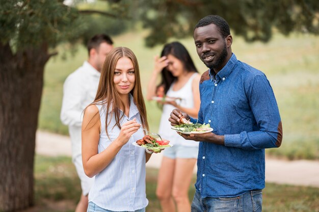 Bunch of friends enjoying barbecue outdoors