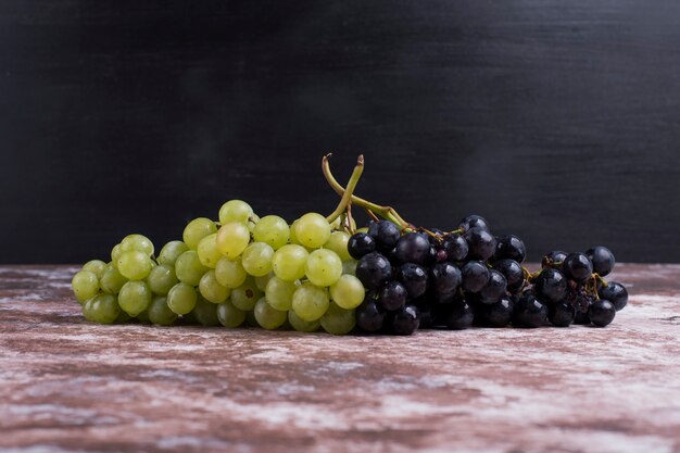 A bunch of green and red grapes on the marble