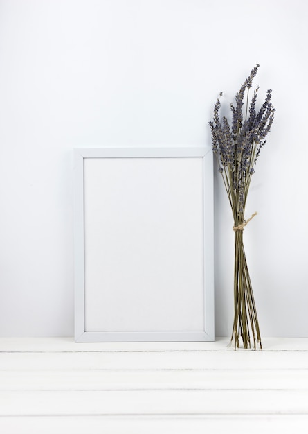 Free photo bunch of lavender flowers with empty frame on wooden desk