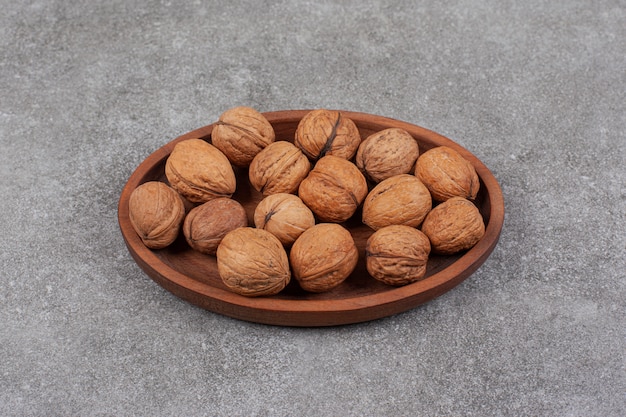 Bunch of organic walnuts on wooden plate