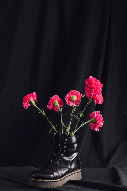 Bunch of pink blooms in dark boot