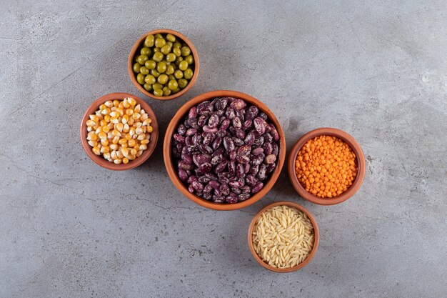 Bunch of raw lentils, beans and rice on stone background. 