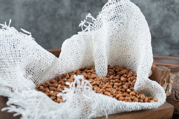 Free photo bunch of red beans in wooden box with burlap.