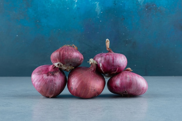 Bunch of red onions on marble.