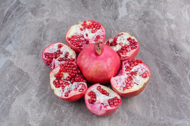 Bunch of red pomegranates on stone surface. 