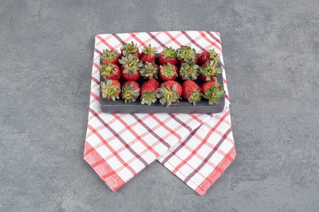 Bunch of red strawberries on black plate. High quality photo