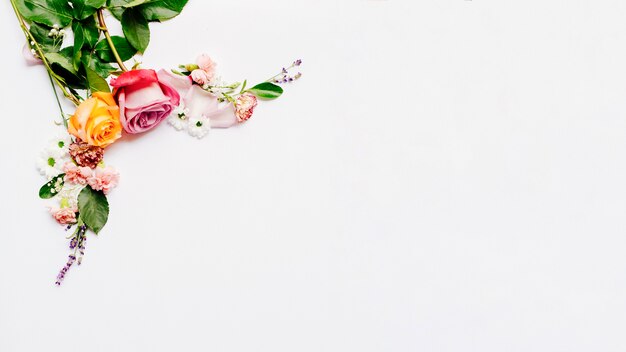 Bunch of small flowers with roses arranged over white backdrop