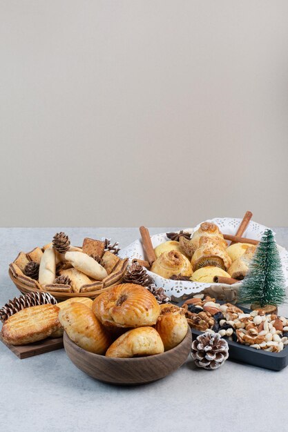 Bunch of various cookies, nuts and pinecones in bowls. High quality photo