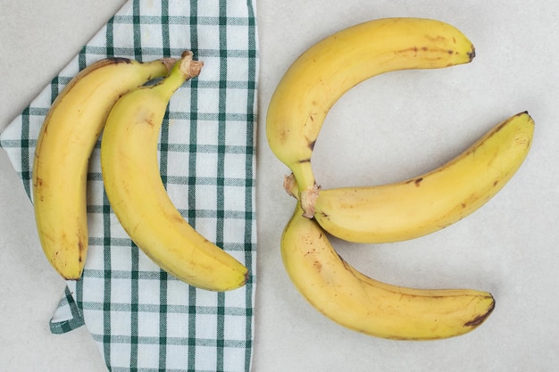 Bunch of yellow bananas on striped tablecloth