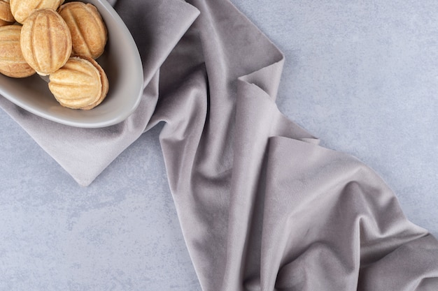 Free photo bundle of caramel filled cookie balls in a bowl on marble table.