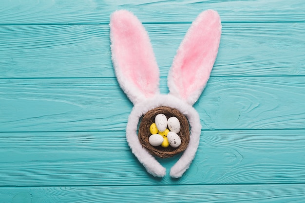 Free photo bunny ears and nest on wooden background