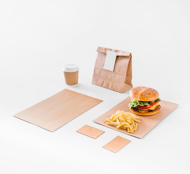 Free Photo burger; french fries; parcel and disposal cup on white backdrop