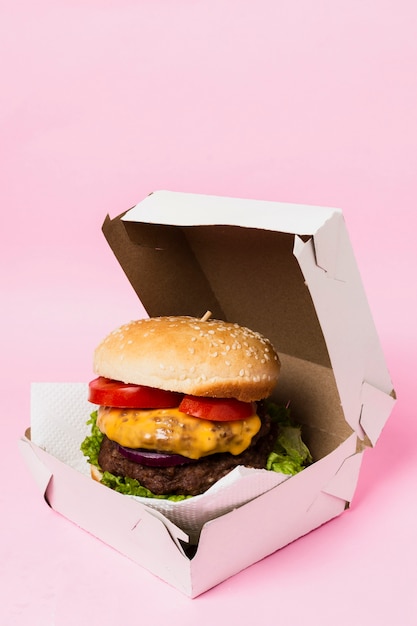 Burger in white box on pink background