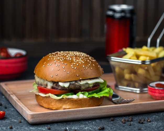 Burger with cotlet, vegetables and mayonnaise sauce.