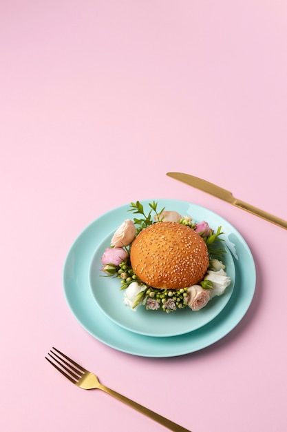 Free Photo burger with flowers on plate high angle