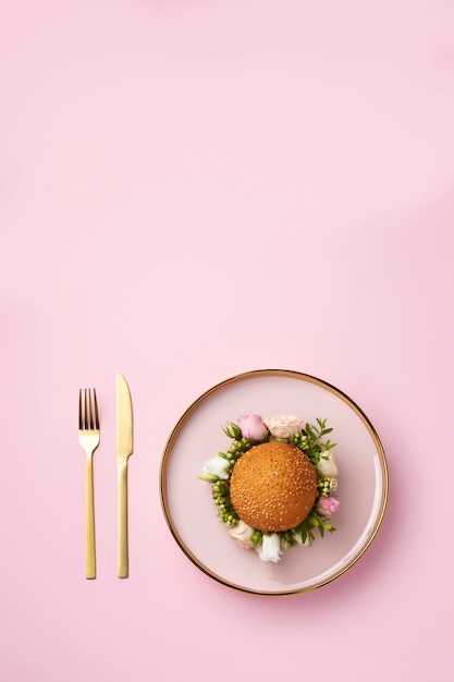 Free Photo burger with flowers on plate top view