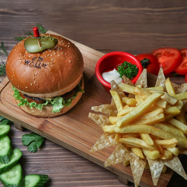 Burger with french fries, cucumber, tomato and sauce