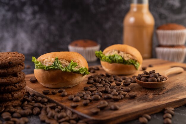 Burger with wooden cutting board, including cupcakes and coffee beans.